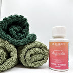 Magnolia scent booster next to towels on white background. 