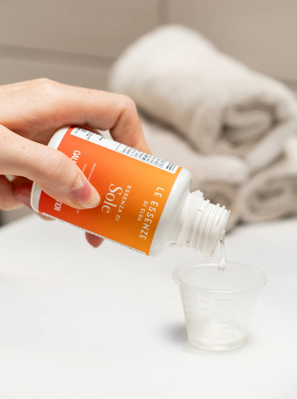 a hand holding a Sole scent booster by aROMA Laundry